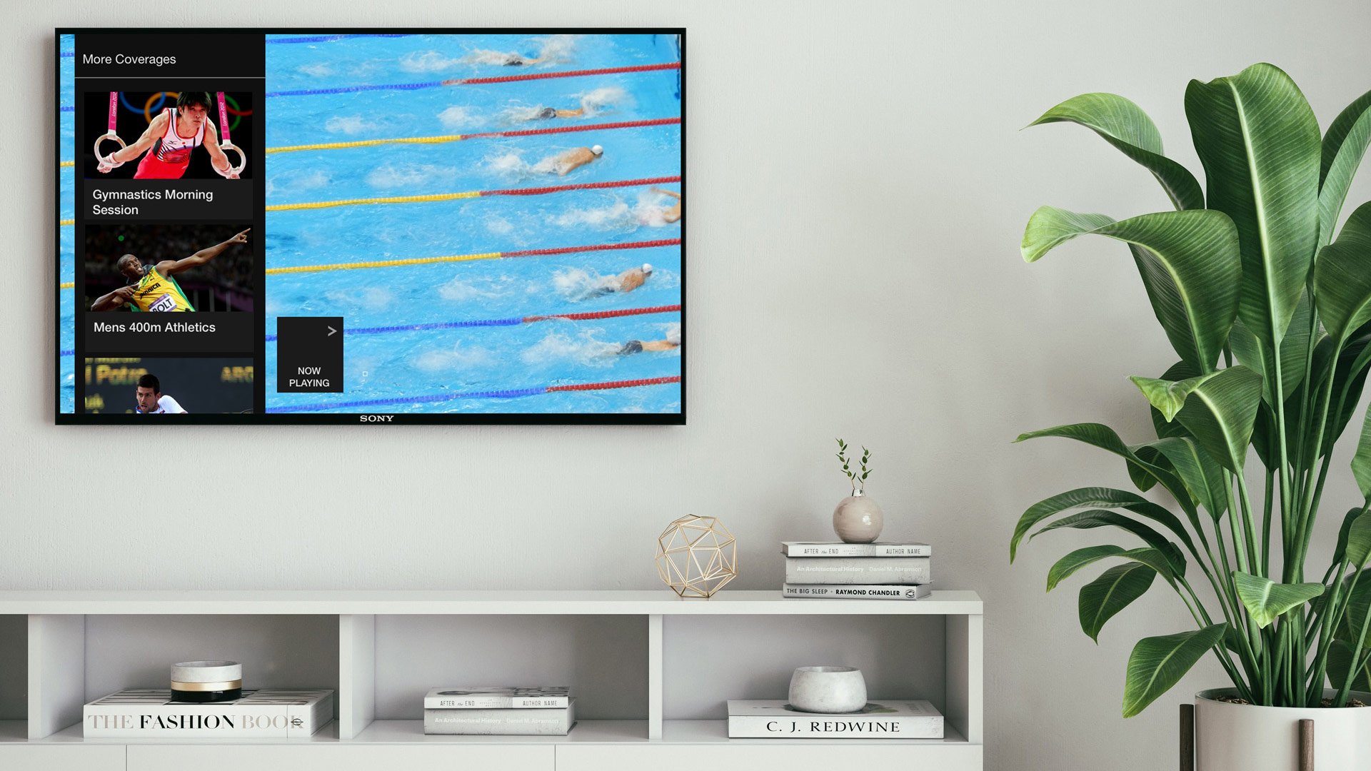 A TV is mounted on the wall of a living room, showing a mockup of the Red Button+ interface. This interface enables the user to switch their current stream. In the background, there is a still image of six swimmers in a pool.
