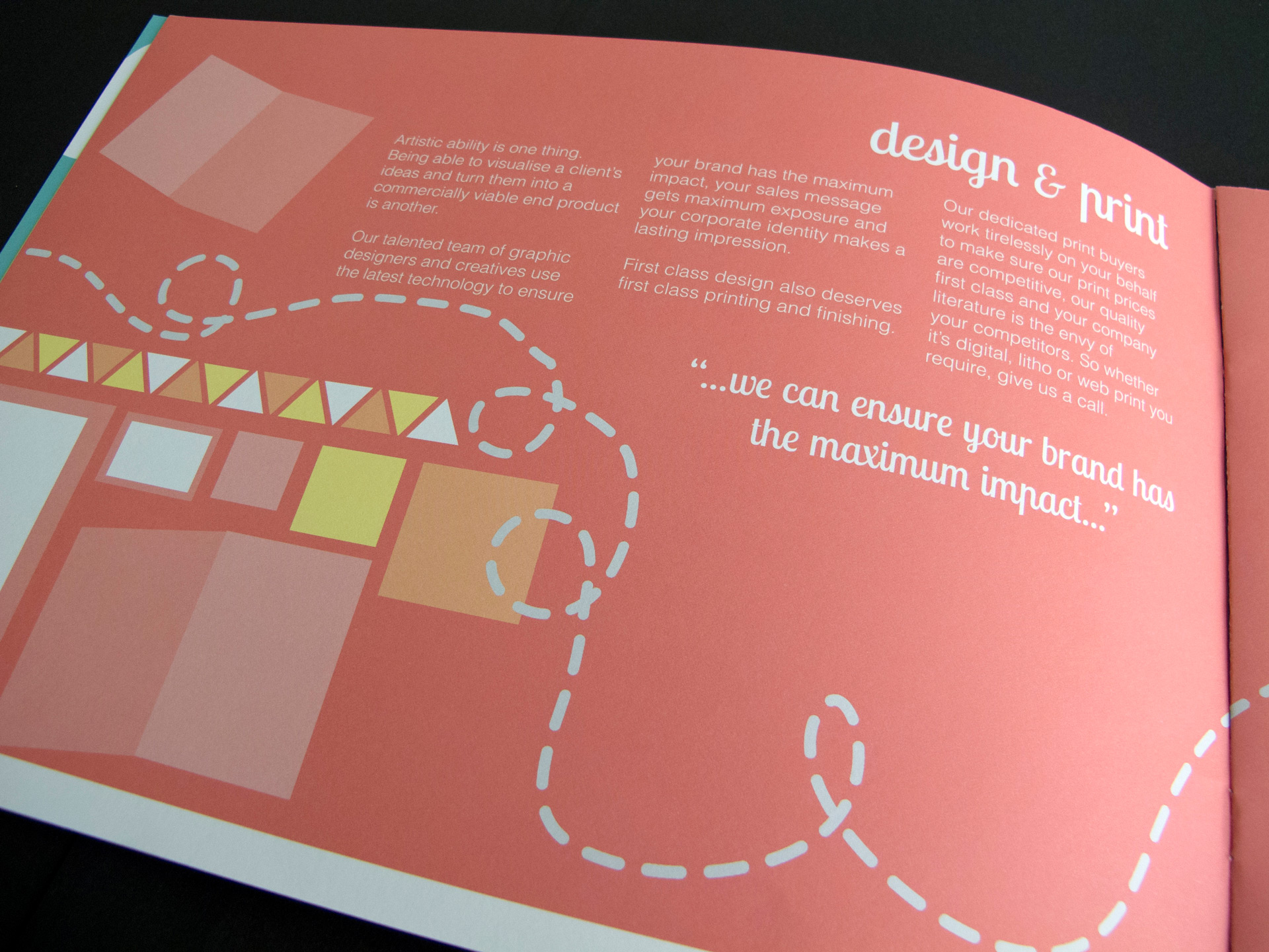 An angled photo of the design and print brochure page. The page is a bright orange colour with white text. The illustrations are in white, peach, and yellow, and depict shape and patterns to represent print design.