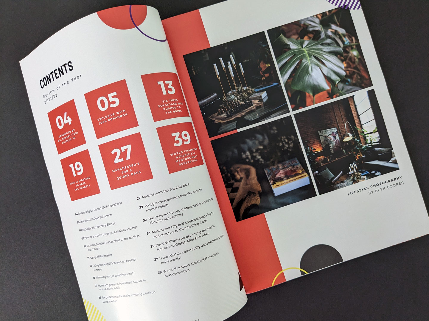 A photo of the magazine's contents and photography page, taken at an angle. The page on the left has the contents, with featured elements highlighted in large red squares with white text. The page on the right showcases four lifestyle photography images by Beth Cooper.